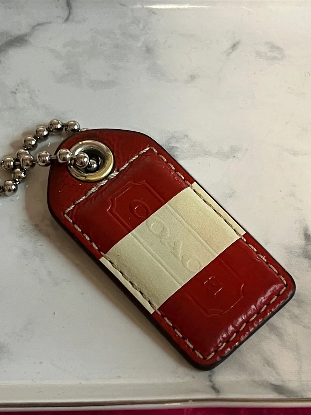 Coach Red and Cream Leather hangtag with ball chain. Preowned condition.